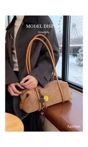 Détail du sac baguette en cuir caramel avec breloque tournesol et fermeture éclair