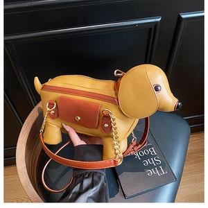 Close-up of a creative dachshund-shaped crossbody bag with gold chain and leather texture