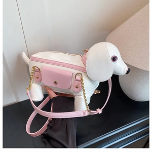 Detail of dog-shaped crossbody bag with pink leather strap and gold chain accessories