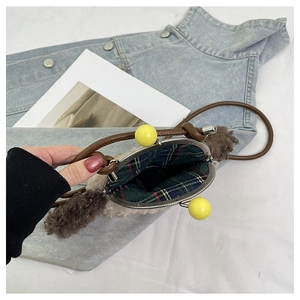 Détail du sac chiot en peluche avec fermoir métallique et doublure en coton à carreaux