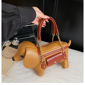 Detail of dachshund-shaped handbag with yellow and brown leather and gold chain