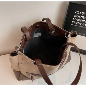 Detail view of large tote bag with contrast leather stitching and silver zip pocket