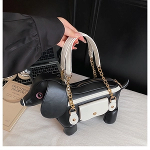 Detail of dachshund puppy purse showing black leather texture and gold chain strap