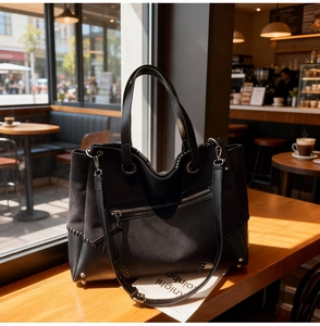Detail of black tote bag with suede leather stitching and handwoven stitching accents