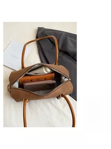 Vue de dessus de l'intérieur du sac en cuir marron montrant sa grande capacité