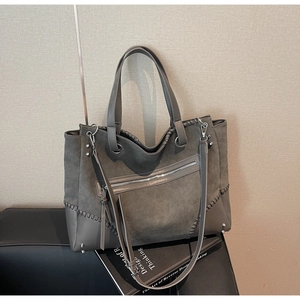 Detail of dark grey retro tote bag with contrasting matte textures and woven stitching
