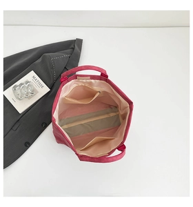Detail view of the rose red tote bag interior showing the zipper pocket and beige lining