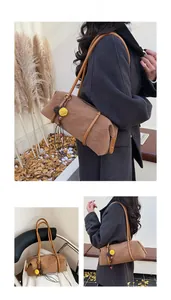 Sac cylindrique en daim marron avec pompons décoratifs et longues anses porté épaule chic