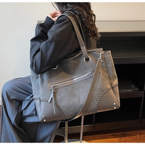 Detail of gray vintage tote bag with visible stitching and adjustable shoulder strap