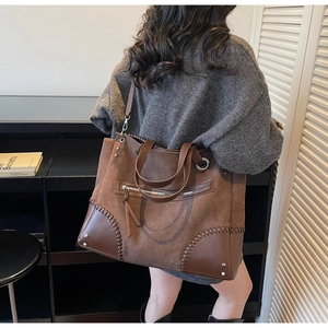 Detail view of large vintage brown tote bag with contrast textures and metal hardware