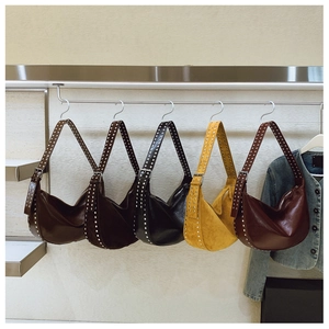 Detail view of five assorted hobo bags with silver rivet trim and adjustable straps