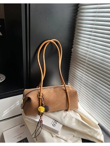 Vue détaillée du sac bandoulière cylindre en daim marron avec fermeture éclair dorée chic