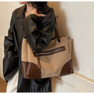Detail of camel suede tote bag with brown leather contrast and braided hand-stitched seams