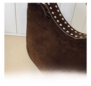 Detail of dark brown suede shoulder bag with polished silver metal rivet studs