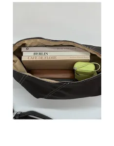 Top view of spacious interior storage of the black crescent bag with books and accessories