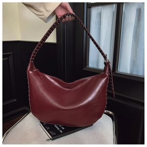 Detail of burgundy hobo bag with silver metallic rivets and zipper closure design