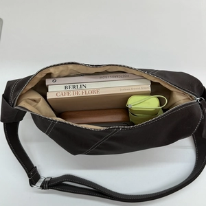 Top-down view of spacious dark brown crossbody bag showing large interior storage capacity