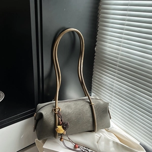 Sac baguette cylindrique vert sauge avec anses métalliques et pompon décoratif