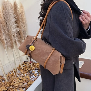 Sac baguette cylindrique en daim marron avec bandoulière et pendentif floral