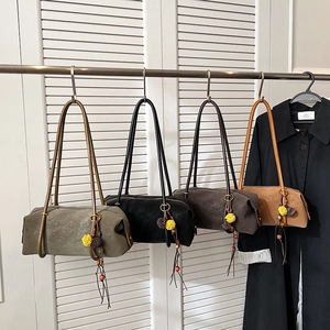 Sac baguette minimaliste en quatre couleurs avec pendentif floral sur fond blanc épuré