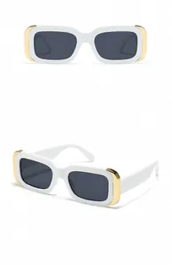 Détail des lunettes de soleil rectangulaires blanches avec accents dorés et verres gris