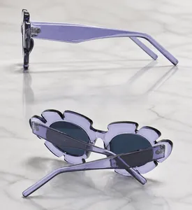 Detail view showing side and back of purple floral-shaped sunglasses with dark lenses