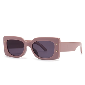 Modern rectangular sunglasses with matte pink frame and gold star studs on white background