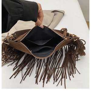 Detail of bohemian brown tassel bag showing black fabric interior and zipper pocket