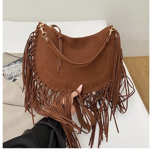 Detail of a brown suede half-moon bag featuring long fringes and gold metal buckles