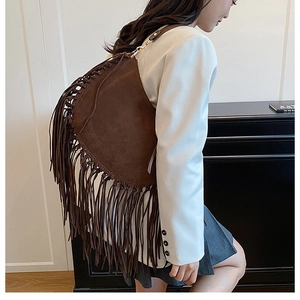 Detail of dark brown bohemian hobo bag featuring long suede fringe and gold hardware