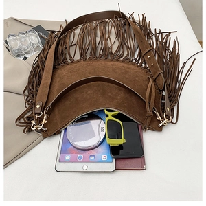 Top view of spacious brown suede crescent bag with long fringes and urban essentials