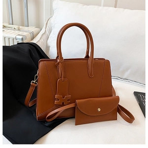 Detail of vintage brown leather tote bag with V-shaped stitching and matching pouch