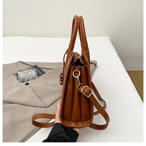 Detail view of tan leather handbag showing triple-layered accordion interior compartments