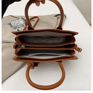 Interior layout of brown commuter tote bag showing spacious triple compartments and zippers