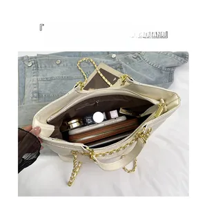 Macro shot of large beige quilted tote bag interior with multiple storage compartments