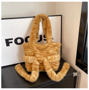 Detail of soft plush tote bag with orange cat stripes and playful furry tail charms