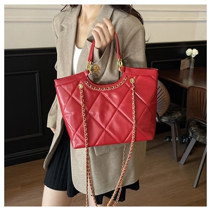 Close-up of red quilted tote bag featuring golden chain straps and premium leather texture