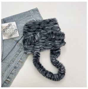 Detail showing plush dark grey faux fur texture on stylish trapper hat with long ties