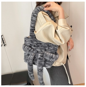 Detail of grey striped faux fur cat-themed tote bag with plush tail decoration