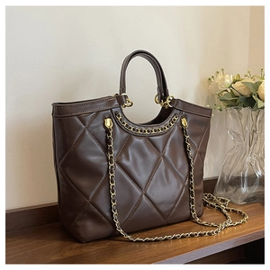Detailed close-up of dark brown quilted tote bag with golden chain and PU leather texture