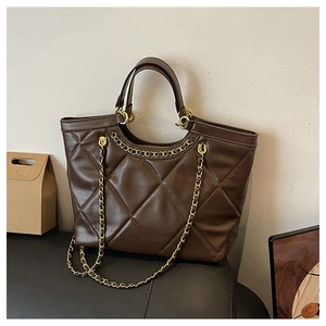Detailed view of the dark brown quilted tote bag with golden chain and glossy finish