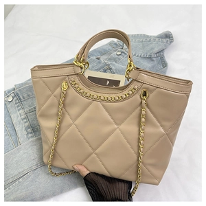 Detail of beige quilted leather handbag with gold chain strap and metal zipper hardware