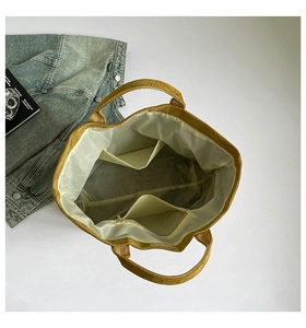 Interior layout of yellow canvas tote bag showing two slip pockets and a zipper compartment