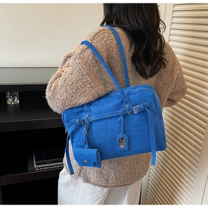 Detailed view of the royal blue suede tote bag with silver buckle and matching mini pouch