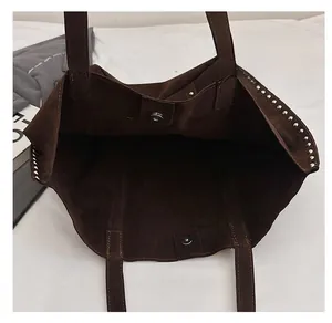 Detail shot of the large dark brown suede tote bag with silver rivets and magnetic closure