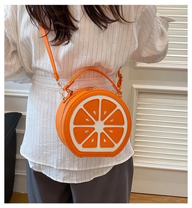 Detail of orange fruit cross-section design on round PU leather crossbody bag