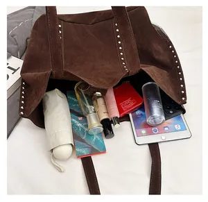 Spacious interior of brown suede tote bag showing tablet and daily essentials