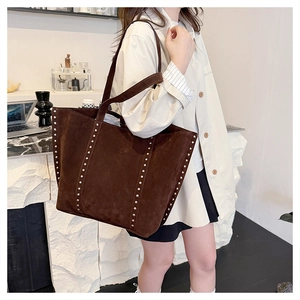 Detail of dark brown faux suede tote bag with vintage silver rivet studs on shoulder strap