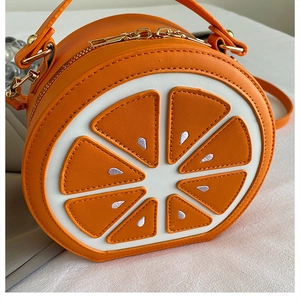 Close-up of orange slice crossbody bag featuring textured PU leather and dual zippers