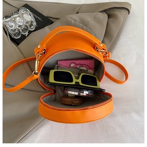 Detailed view of the open orange round lemon crossbody bag showing its interior storage space
